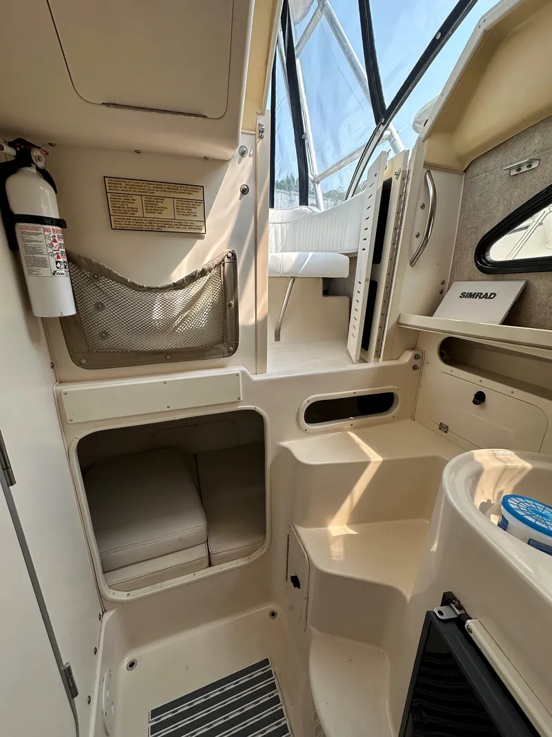 Slide: The Image of Interior of 2001 Grady-White 282 Sailfish boat, featuring steps and storage compartments. - 13