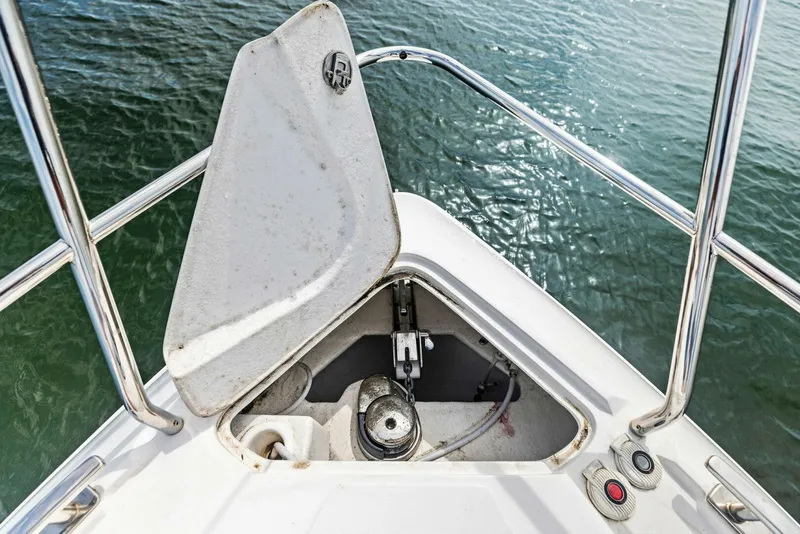 Slide: The Image of Open anchor compartment on 2022 Schaefer 400 Coupe boat, with water view. - 36