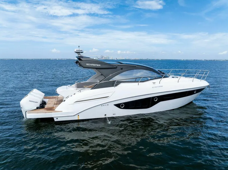 Slide: The Image of 2022 Schaefer 400 Coupe yacht cruising on open water under a clear blue sky. - 39
