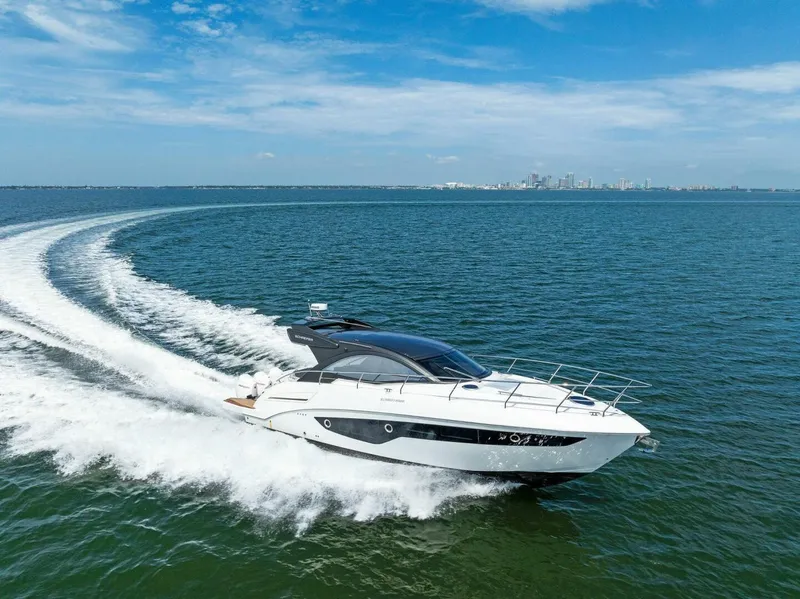 Slide: The Image of 2022 Schaefer 400 Coupe yacht cruising on open water under a clear blue sky. - 46