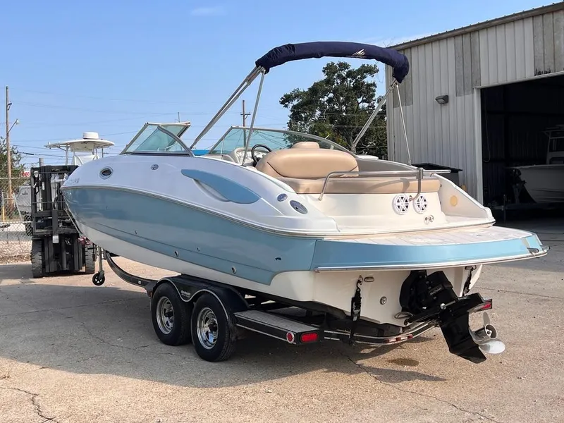 Slide: The Image of 2005 Monterey 220 Explorer Sport boat on trailer near a warehouse. - 4