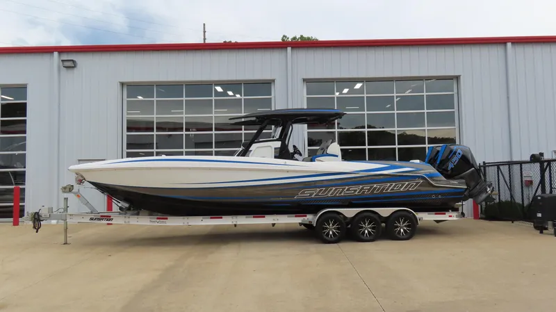 The Image of 2023 Sunsation 32 CCX boat on trailer outside a garage. - 0