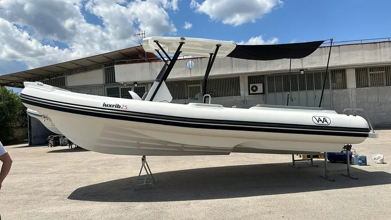 Slide: The Image of Aqvaboats Luxrib 25, 2025 model, white inflatable boat with canopy, parked outdoors. - 9