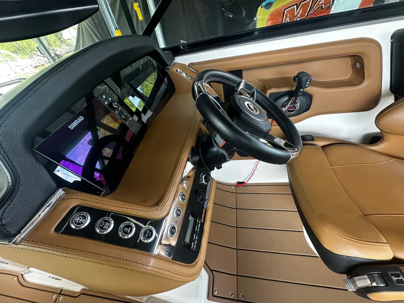 Slide: The Image of Interior of 2021 Chaparral 26 Surf with modern dashboard and leather seating. - 11