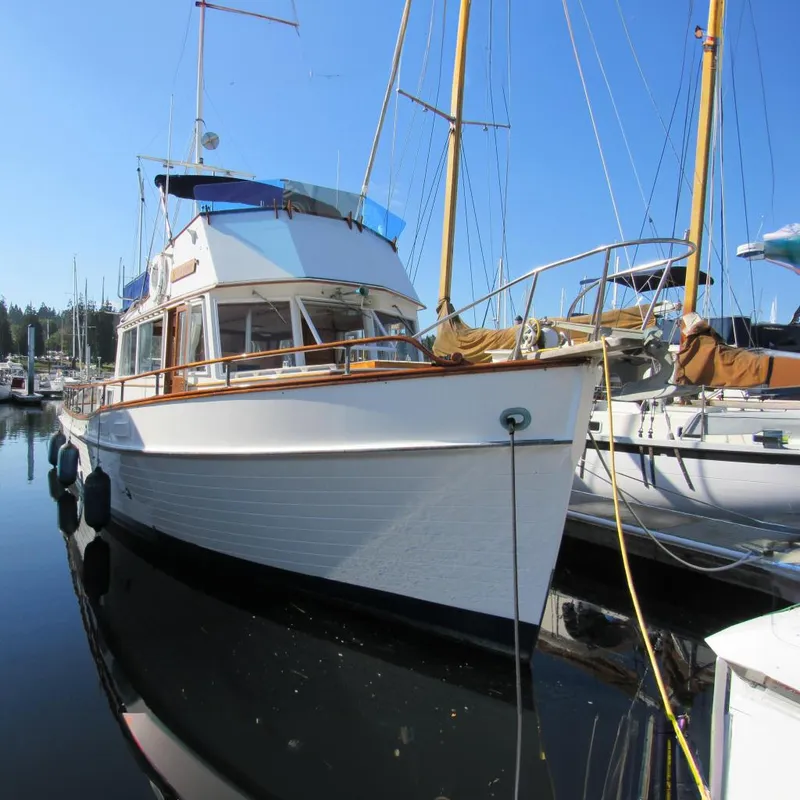 The Image of 1973 Grand Banks 42 Classic yacht docked at a marina under clear blue skies. - 0