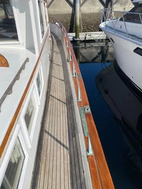 Slide: The Image of 1973 Grand Banks 42 Classic yacht docked, showcasing wooden deck and sleek design. - 14