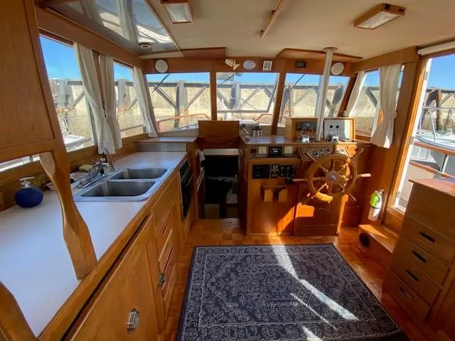 Slide: The Image of 1973 Grand Banks 42 Classic yacht interior with wooden helm, kitchen, and nautical decor. - 21