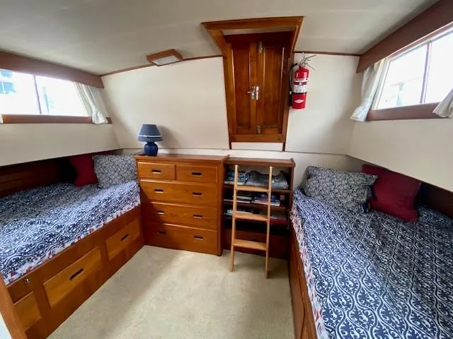 Slide: The Image of 1973 Grand Banks 42 Classic cabin with twin beds, wooden drawers, and nautical decor. - 25