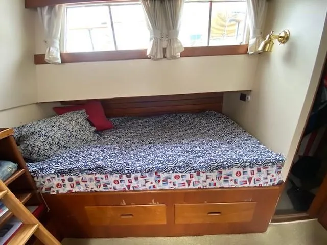 Slide: The Image of Cozy cabin bed in 1973 Grand Banks 42 Classic yacht with patterned bedding and wooden storage. - 26
