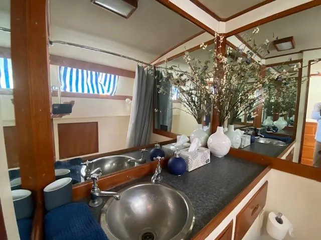 Slide: The Image of 1973 Grand Banks 42 Classic yacht bathroom with sink, mirror, and decorative vases. - 29