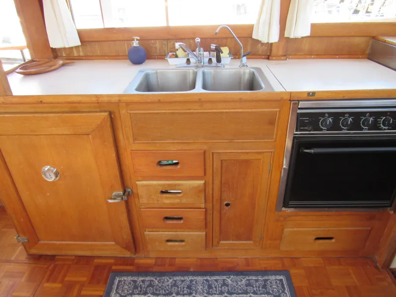 Slide: The Image of 1973 Grand Banks 42 Classic kitchen with wooden cabinetry, double sink, and oven. - 32