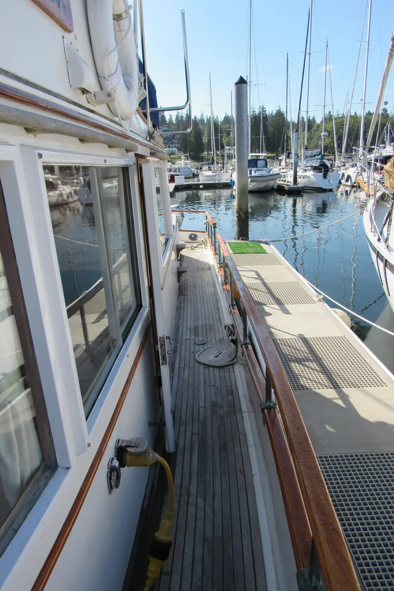 Slide: The Image of 1973 Grand Banks 42 Classic yacht docked at a marina, showcasing its wooden deck and side view. - 35