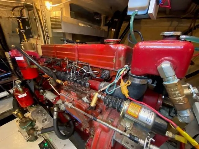 Slide: The Image of Engine room of a 1973 Grand Banks 42 Classic, featuring a red marine engine. - 42