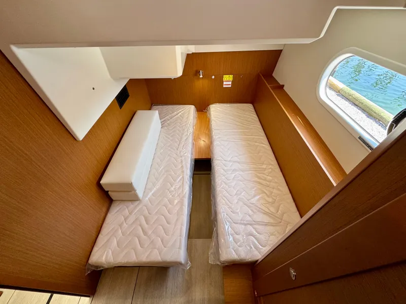 Slide: The Image of 2025 Beneteau Swift Trawler 41 Fly cabin with twin beds and wooden interior. - 12