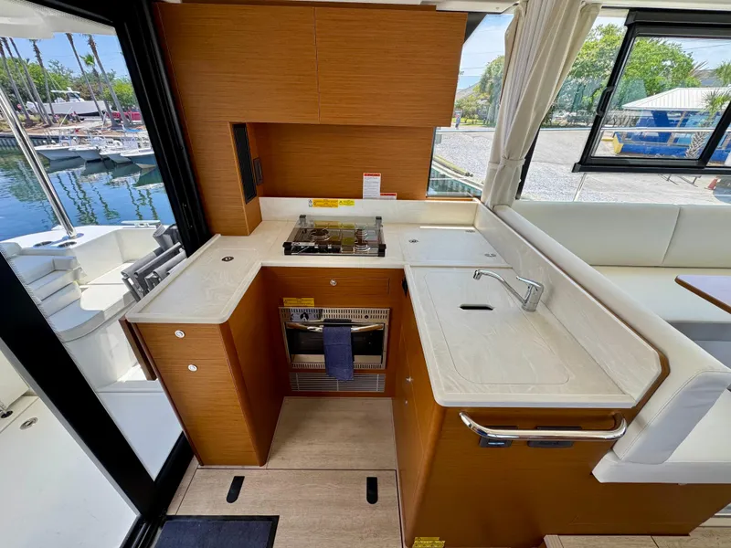 Slide: The Image of 2025 Beneteau Swift Trawler 41 Fly kitchen with modern appliances and marina view. - 13