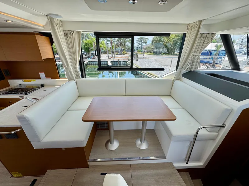 Slide: The Image of Interior of 2025 Beneteau Swift Trawler 41 Fly with white seating and wooden table. - 15