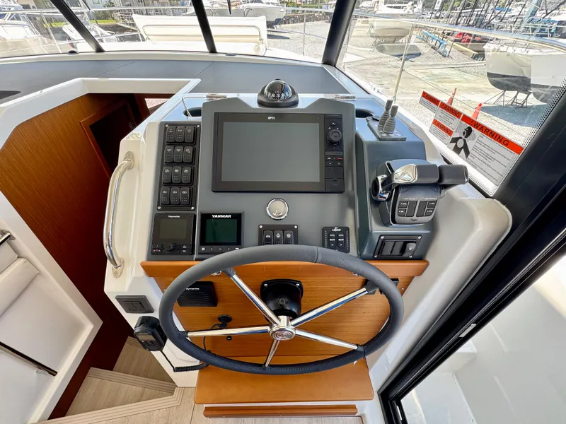 Slide: The Image of 2025 Beneteau Swift Trawler 41 Fly helm with advanced navigation controls and steering wheel. - 19