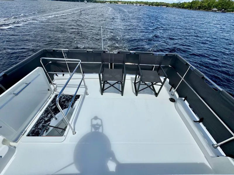 Slide: The Image of 2025 Beneteau Swift Trawler 41 Fly deck with chairs, overlooking serene water. - 20