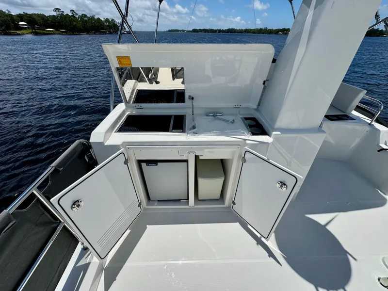 Slide: The Image of 2025 Beneteau Swift Trawler 41 Fly deck with open storage compartments and water view. - 21