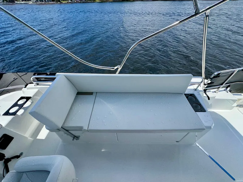Slide: The Image of 2025 Beneteau Swift Trawler 41 Fly deck with white seating, overlooking water. - 22