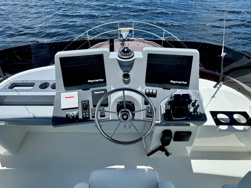 Slide: The Image of 2025 Beneteau Swift Trawler 41 Fly helm with dual Raymarine displays on open water. - 24