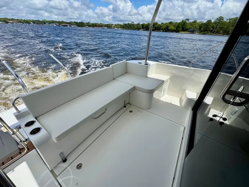 Slide: The Image of 2025 Beneteau Swift Trawler 41 Fly, spacious deck with seating, cruising on open water. - 26