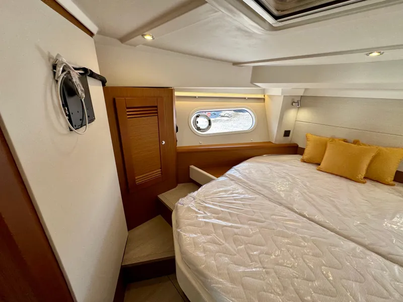 Slide: The Image of 2025 Beneteau Swift Trawler 41 Fly cabin with cozy bed and porthole window. - 4