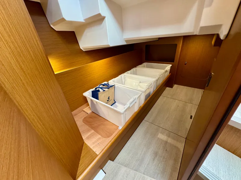 Slide: The Image of Interior storage area of 2025 Beneteau Swift Trawler 41 Fly with organized bins. - 8