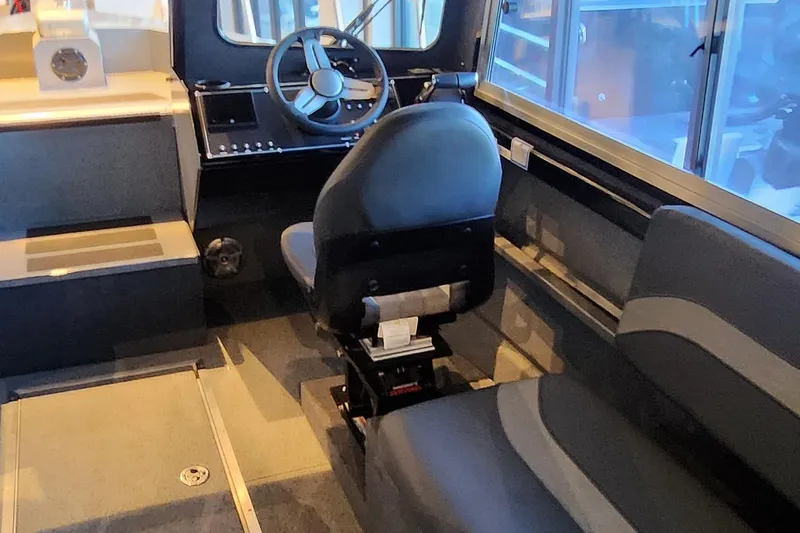 Slide: The Image of 2024 Spartan 260 Maximus Pro XL boat interior with steering wheel and seating. - 3