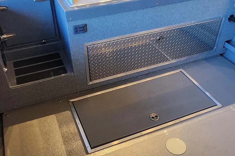 Slide: The Image of 2024 Spartan 260 Maximus Pro XL interior with storage compartments and diamond plate detailing. - 4