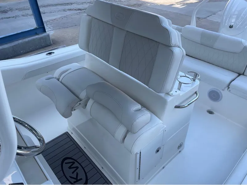 Slide: The Image of 2025 Key West 239 FS boat interior with white cushioned seating and steering wheel. - 13