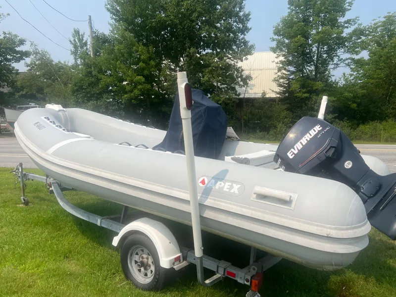 Slide: The Image of 2005 Apex Marine 17 inflatable boat with Evinrude motor on trailer, parked on grass. - 10