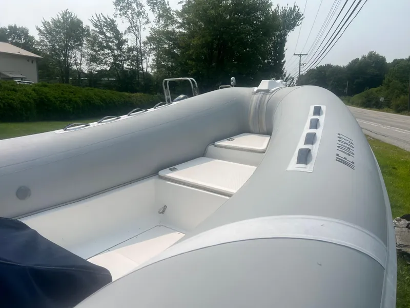 Slide: The Image of 2005 Apex Marine 17 inflatable boat on roadside, surrounded by greenery. - 11