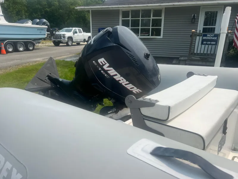 Slide: The Image of 2005 Apex Marine 17 boat with Evinrude outboard motor, parked near a house. - 12