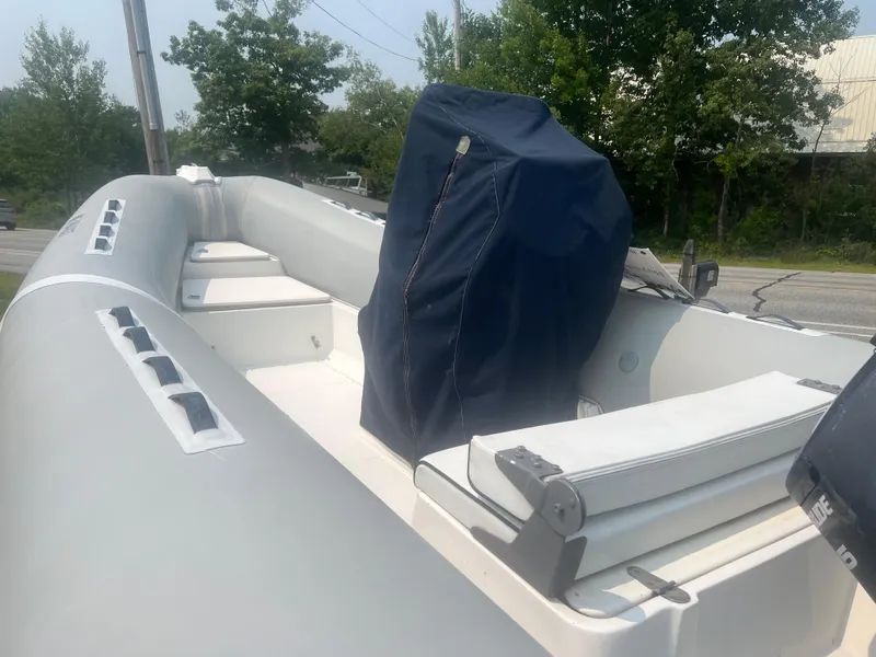 Slide: The Image of 2005 Apex Marine 17 boat with covered seating, parked outdoors. - 8