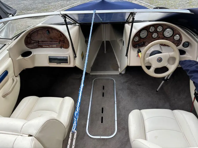 Slide: The Image of Interior of a 1999 Stingray 190RS boat, featuring beige seats and dashboard. - 17
