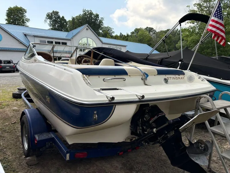 Slide: The Image of 1999 Stingray 190RS boat on trailer, American flag, outdoor setting. - 3