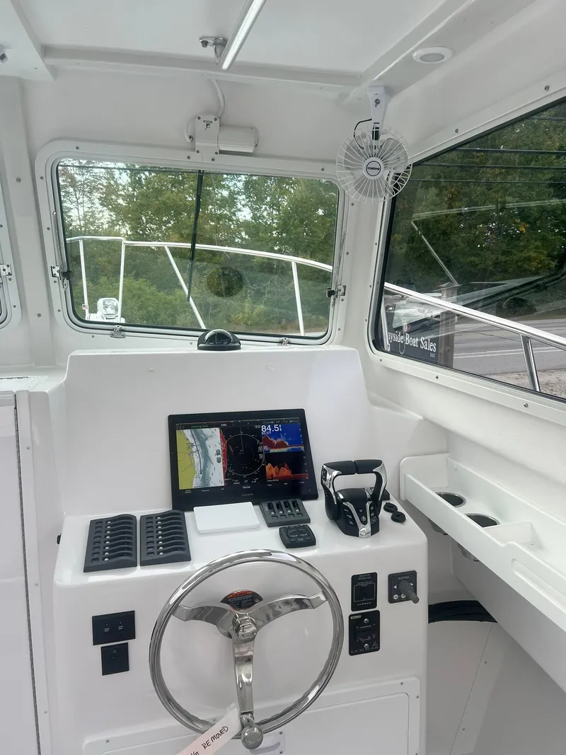 Slide: The Image of 2024 Steiger Craft 31 Fisherman boat cockpit with steering wheel and navigation equipment. - 10