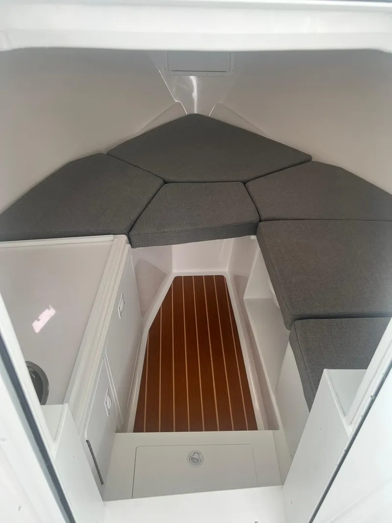 Slide: The Image of 2024 Steiger Craft 31 Fisherman cabin interior with cushioned seating and wood flooring. - 19