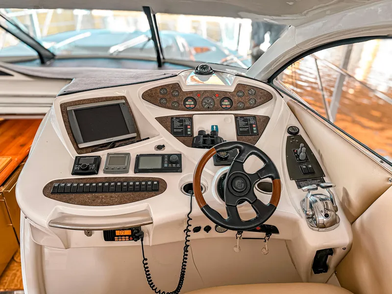 Slide: The Image of Sunseeker Predator 61 yacht helm, 2002 model, featuring advanced navigation controls and steering wheel. - 10