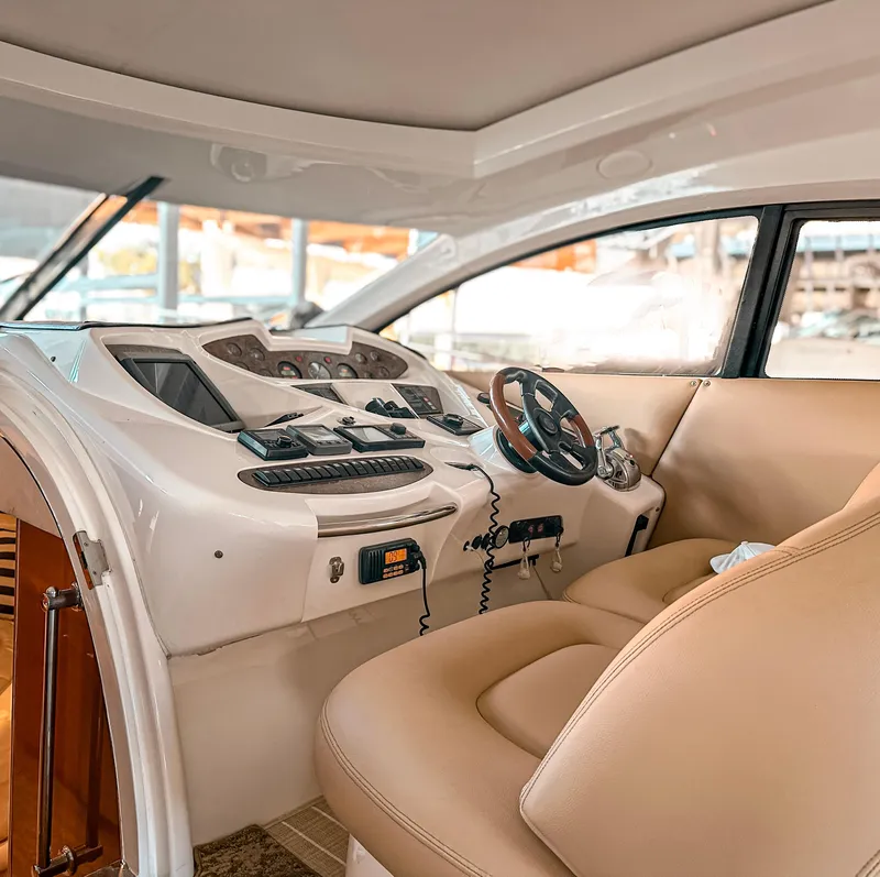 Slide: The Image of Interior cockpit of 2002 Sunseeker Predator 61 yacht with beige seating and control panel. - 11