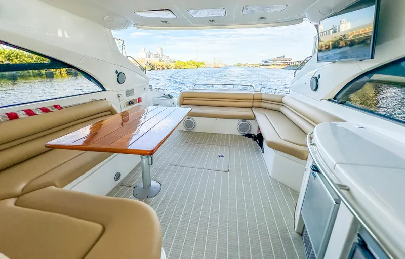 Slide: The Image of Luxurious 2002 Sunseeker Predator 61 yacht interior with elegant seating and scenic water view. - 12