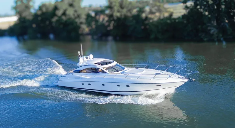 Slide: The Image of 2002 Sunseeker Predator 61 yacht cruising on a serene river. - 2