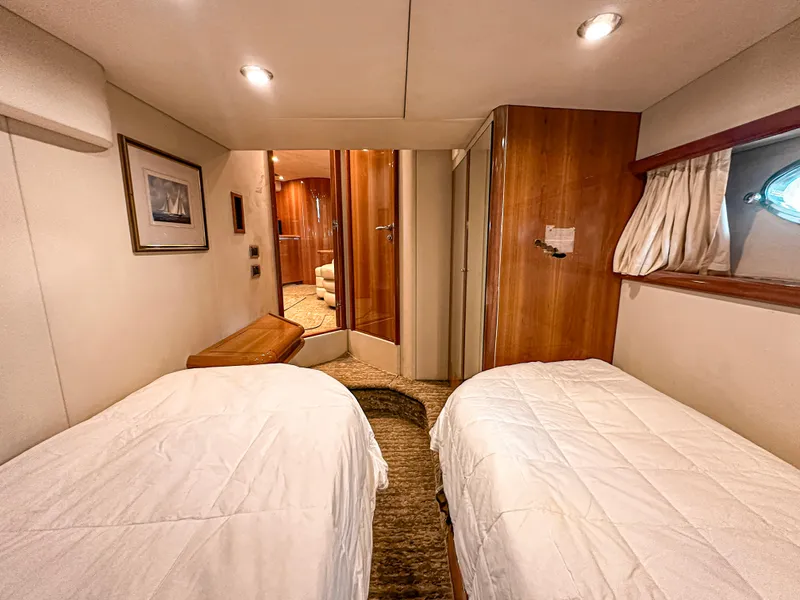 Slide: The Image of Luxurious 2002 Sunseeker Predator 61 yacht cabin with twin beds and elegant wood finishes. - 24