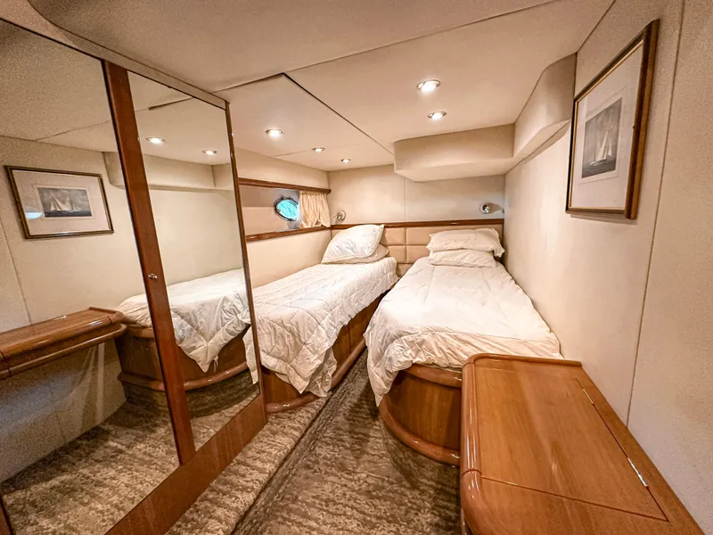 Slide: The Image of Luxurious twin cabin in 2002 Sunseeker Predator 61 yacht, featuring elegant wood finishes. - 25
