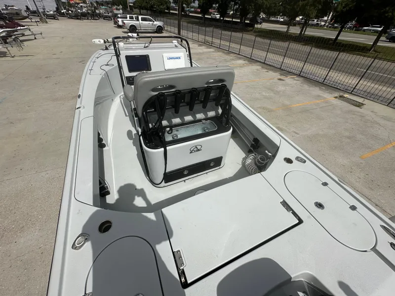 Slide: The Image of 2021 Blazer 2700 HYBRID BAY boat interior with console and seating, parked outdoors. - 11