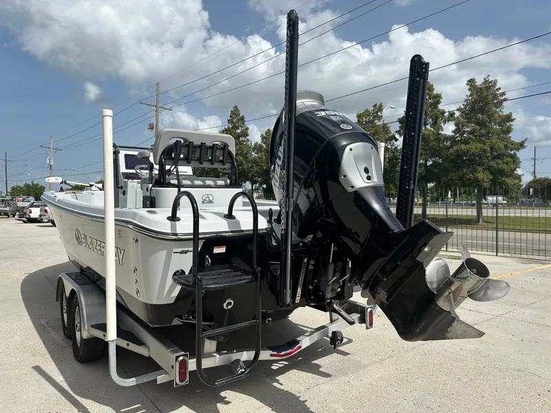 Slide: The Image of 2021 Blazer 2700 HYBRID BAY boat on trailer, featuring powerful outboard motor. - 4