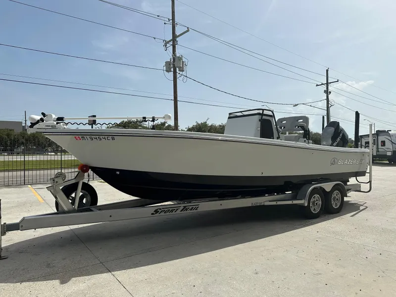 Slide: The Image of 2021 Blazer 2700 HYBRID BAY boat on trailer in sunny outdoor setting. - 6