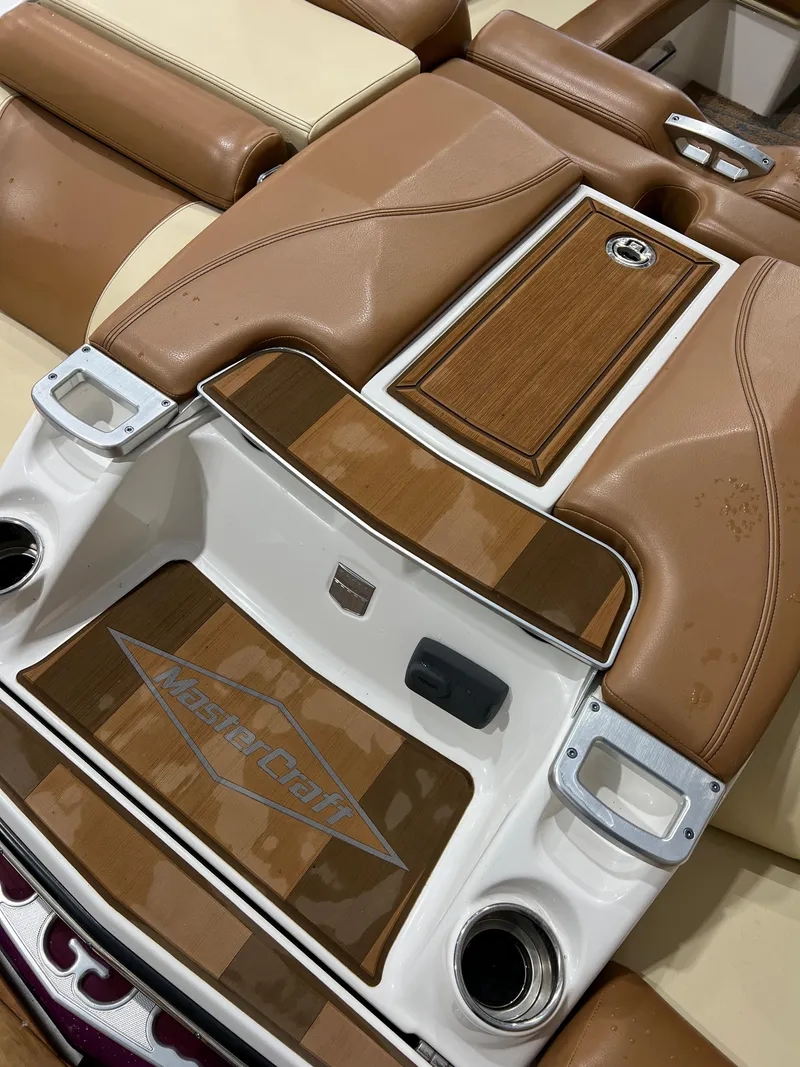 Slide: The Image of 2016 MasterCraft X26 boat interior with tan leather and wood accents. - 13