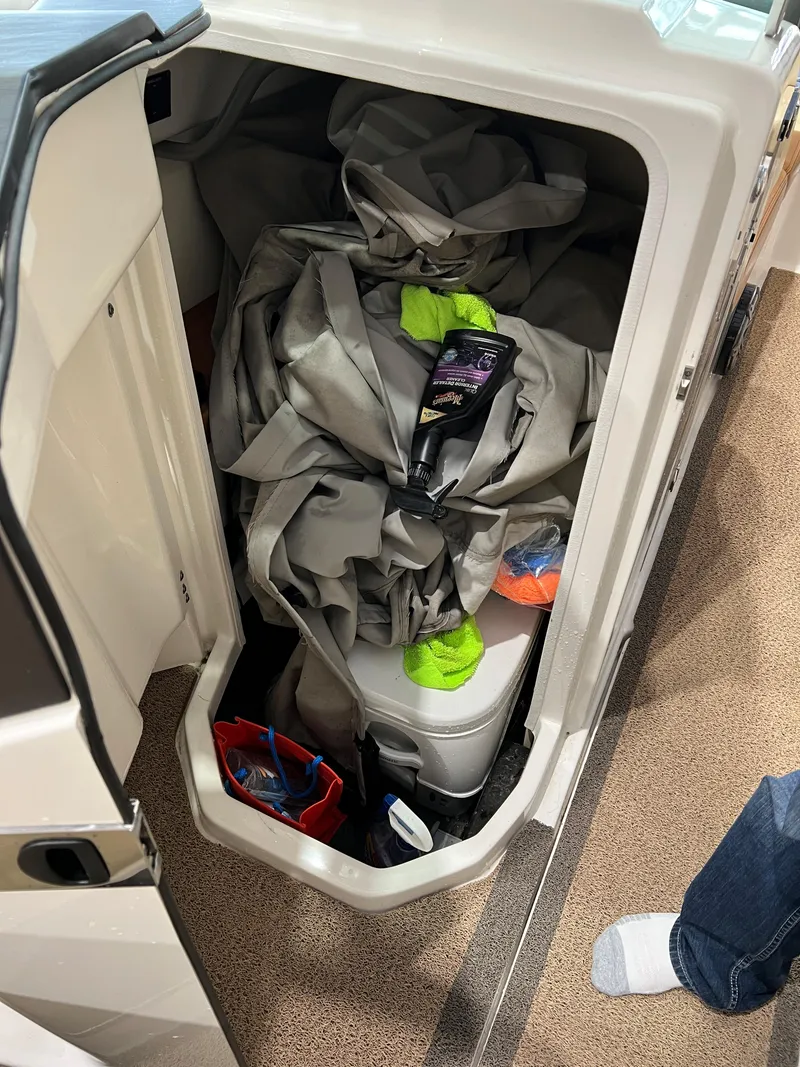 Slide: The Image of Storage compartment in 2016 MasterCraft X26 boat with various items inside. - 15